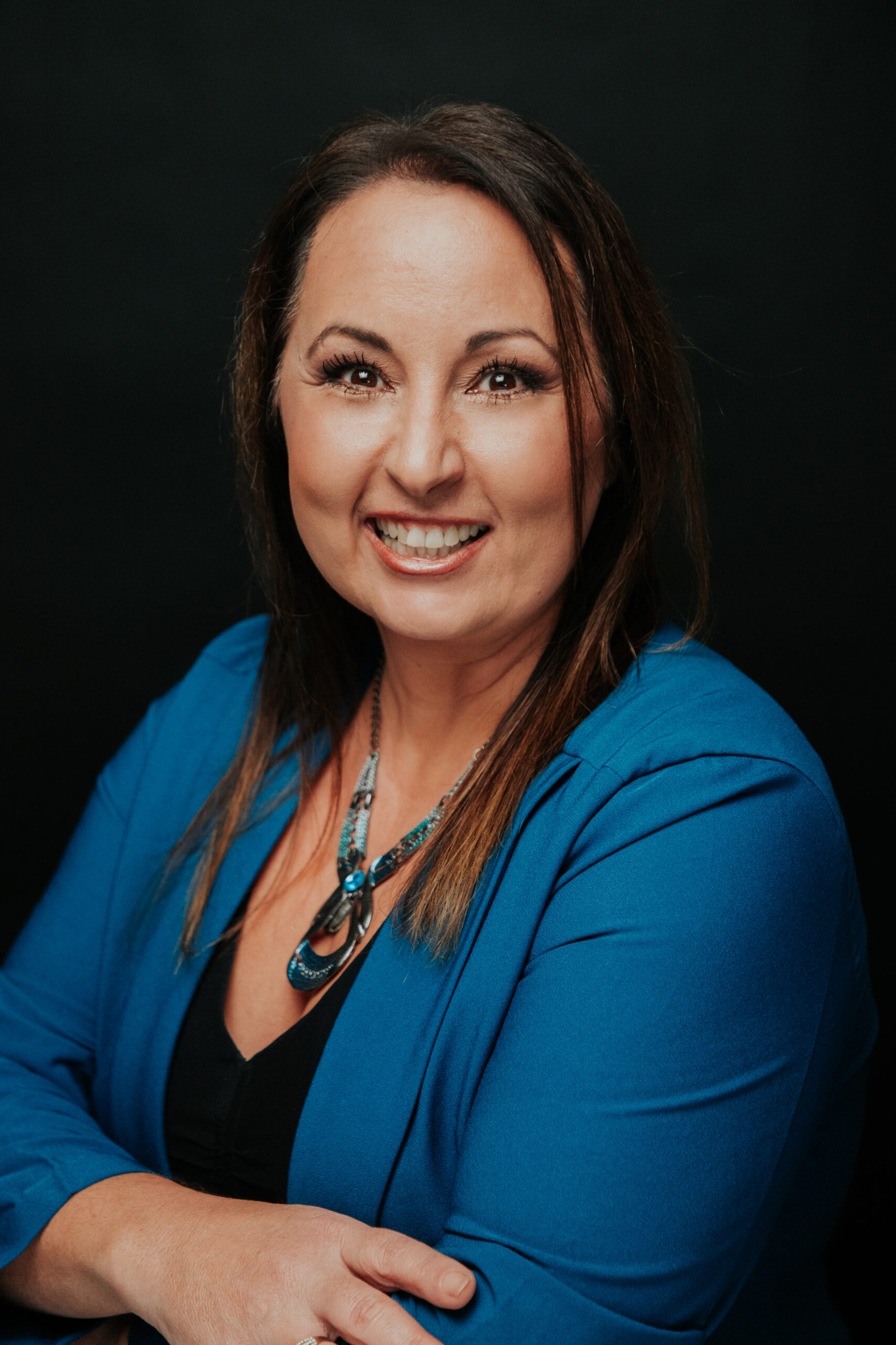 A woman in blue jacket smiling for the camera.